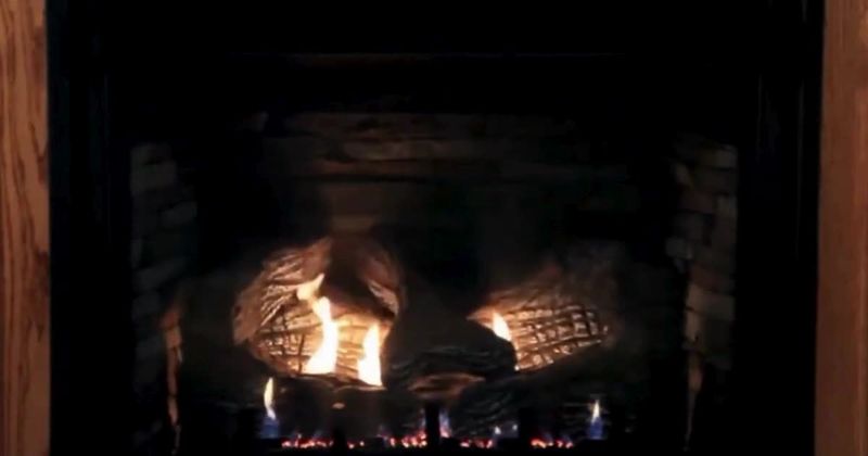 Gas log set burning in a dark firebox