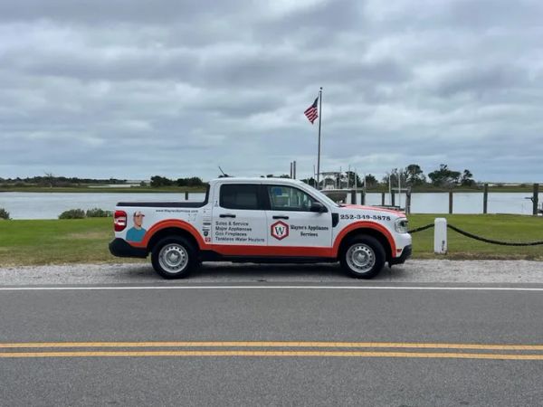 Wayne's Appliance Services work truck parked beside the water